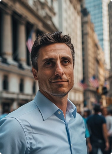 A man with dark hair in a blue shirt standing on a bustling city street, looking slightly to the side with a focused expression.