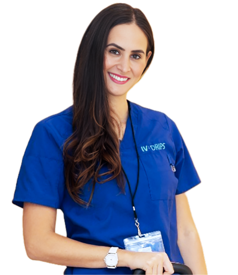 A smiling woman in blue medical scrubs, labeled "iv-drips," with a badge, wearing a watch, standing against a white background.