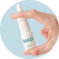 A hand holding a small nasal spray bottle labeled "nad" against a light blue background.