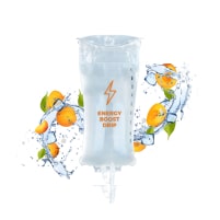 A clear IV drip bag labeled "Energy Boost Drip" with splashes of water, ice cubes, and oranges in the background.